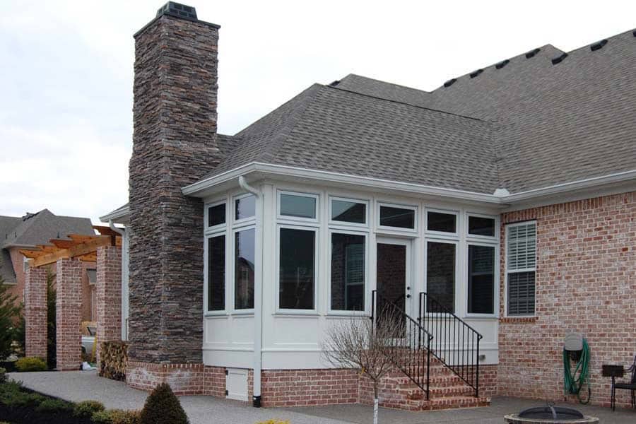 Custom outdoor fireplace and sunroom addition on a brick home in Nashville, showcasing elegant design and craftsmanship by DW Construction.