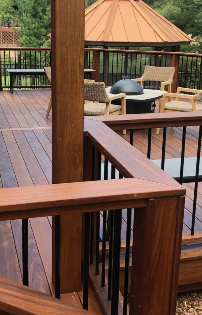 Wooden deck featuring a modern outdoor fire pit, comfortable seating, and a gazebo with a copper roof, illustrating luxury outdoor living by DW Construction in Nashville, TN.
