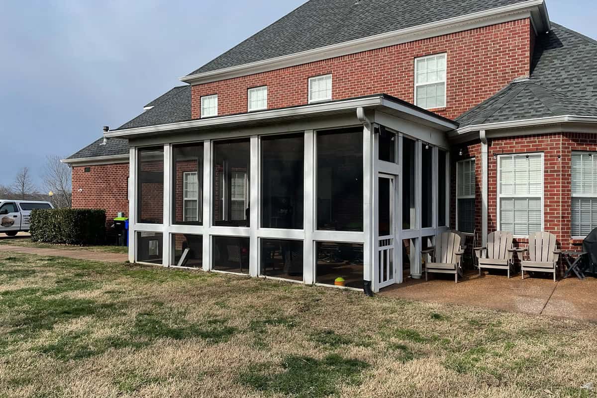 Screened porch attached to a brick house in West Meade, TN, featuring comfortable seating and a spacious outdoor area for relaxation and enjoyment.