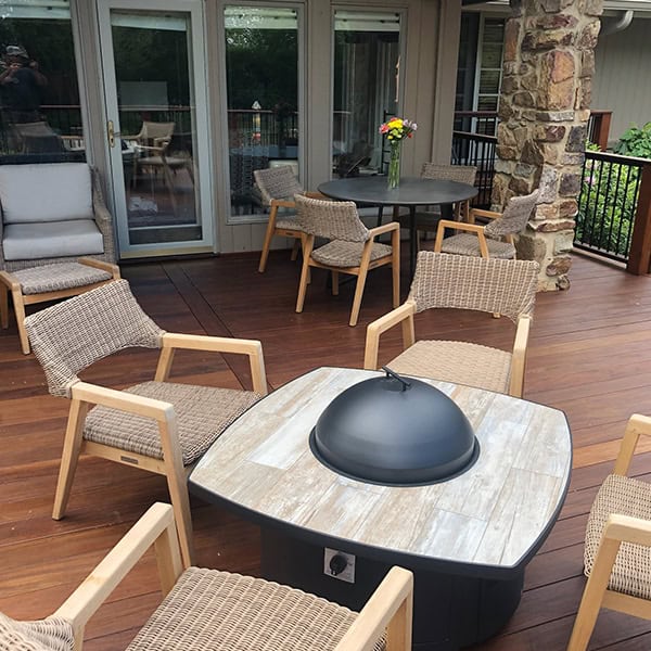 Custom outdoor fire pit with seating area on a wooden deck, enhancing the ambiance of the outdoor living space, designed by DW Construction in Nashville, TN.