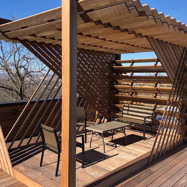 Custom wooden pergola with modern design, featuring slatted roof and seating area, enhancing outdoor living space in Nashville, TN.