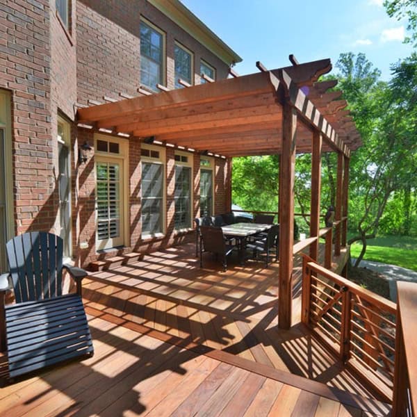 Custom wooden pergola over a wooden deck, enhancing outdoor living space with seating area and natural light filtering through, complementing residential architecture in Nashville, TN.