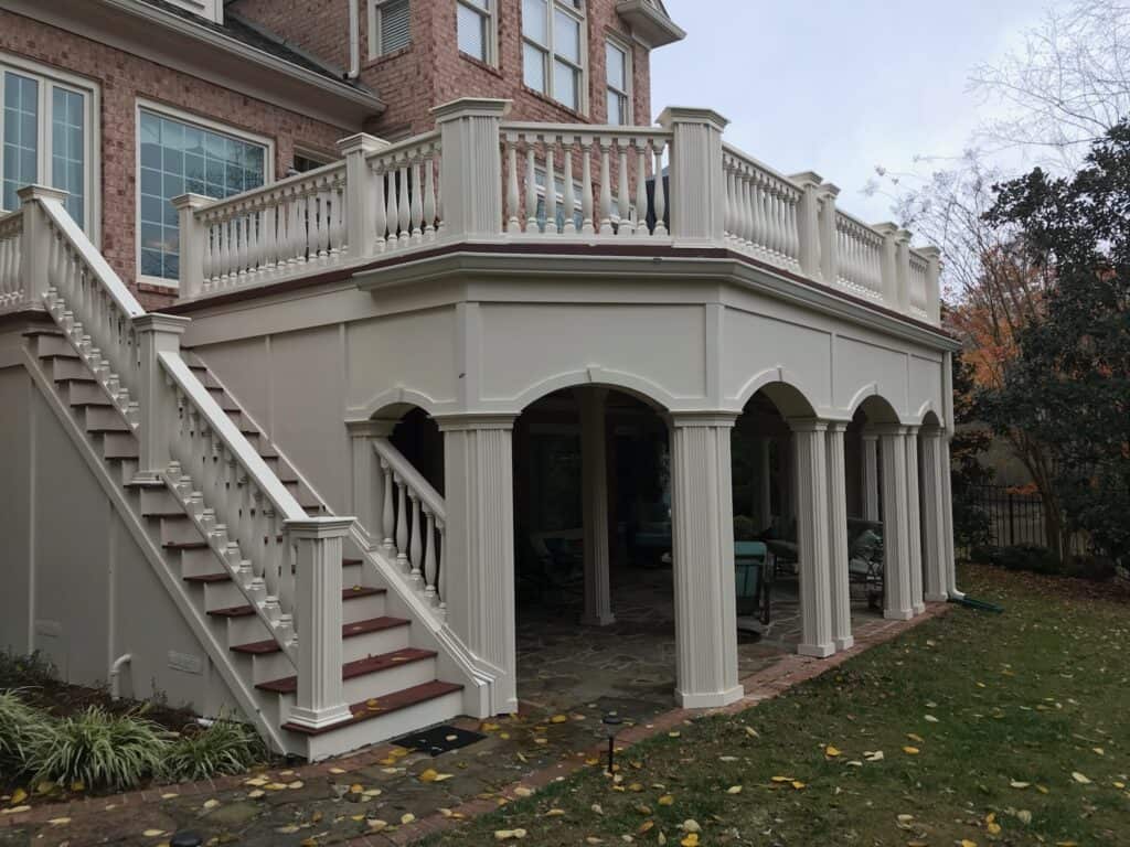 Custom outdoor living space featuring a multi-level deck with elegant railing, staircase, and arched columns, showcasing DW Construction's craftsmanship in Nashville.