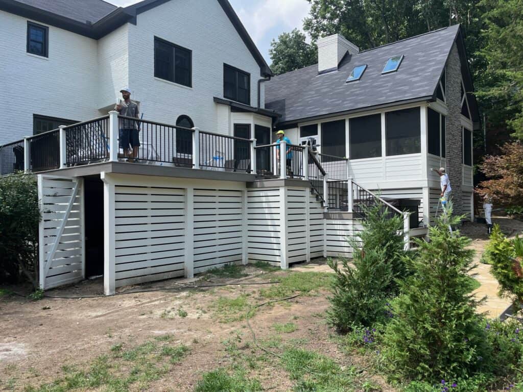 Custom outdoor deck construction with contractors working on a residential property in Nashville, showcasing the design and craftsmanship of DW Construction.
