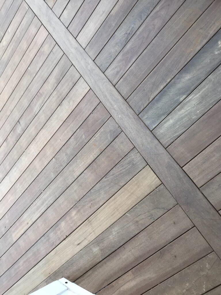 Wooden deck flooring with a diagonal pattern, showcasing high-quality materials used in outdoor construction projects by DW Construction.