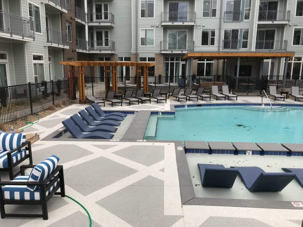 Outdoor living space featuring a pool, lounge chairs, and a pergola, designed by DW Construction for relaxation and entertainment in Nashville, TN.