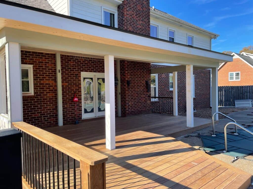 Custom outdoor living space featuring a wooden deck and covered porch with brick siding, designed by DW Construction in Nashville, TN.