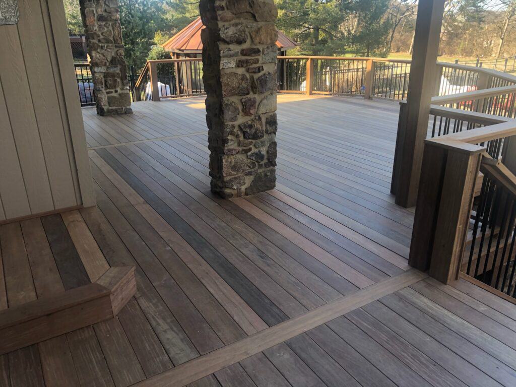 Custom wooden deck with stone pillars and railing, showcasing quality craftsmanship for outdoor living spaces in Nashville.