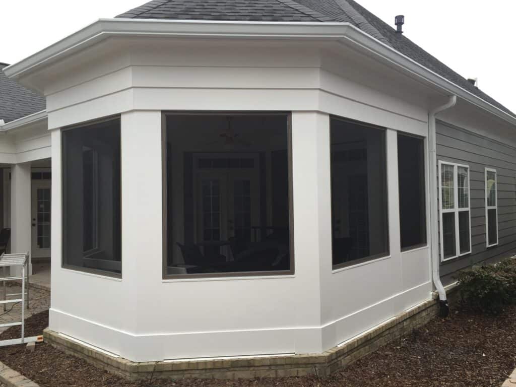 Custom screened-in porch with modern design, featuring large windows and white trim, showcasing DW Construction's outdoor living expertise.