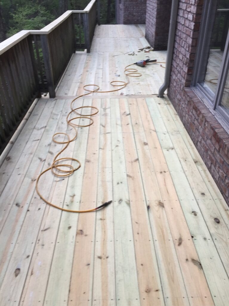 Newly constructed wooden deck with fresh planks, construction tools, and electrical cord, showcasing DW Construction's outdoor living project in Nashville.