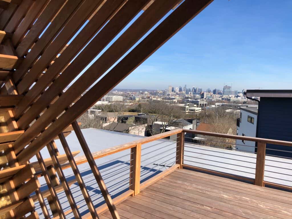 Wooden deck with modern railing overlooking Nashville skyline, showcasing outdoor living space design by DW Construction.