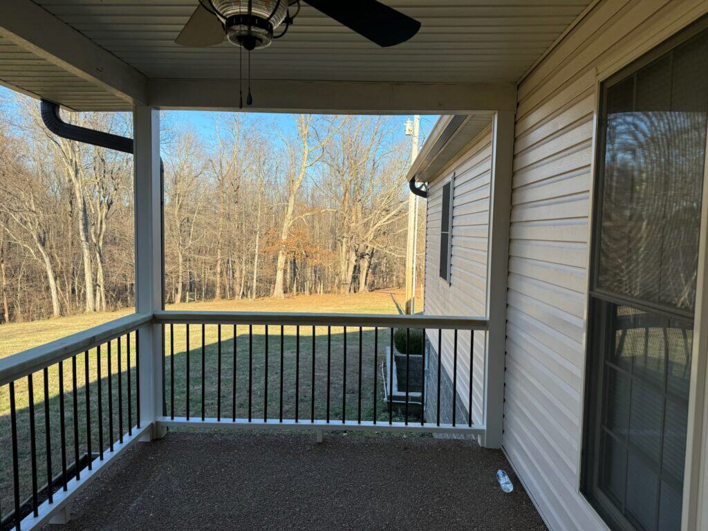 Covered porch view with railing, showcasing outdoor living space and natural surroundings in Nashville, TN.