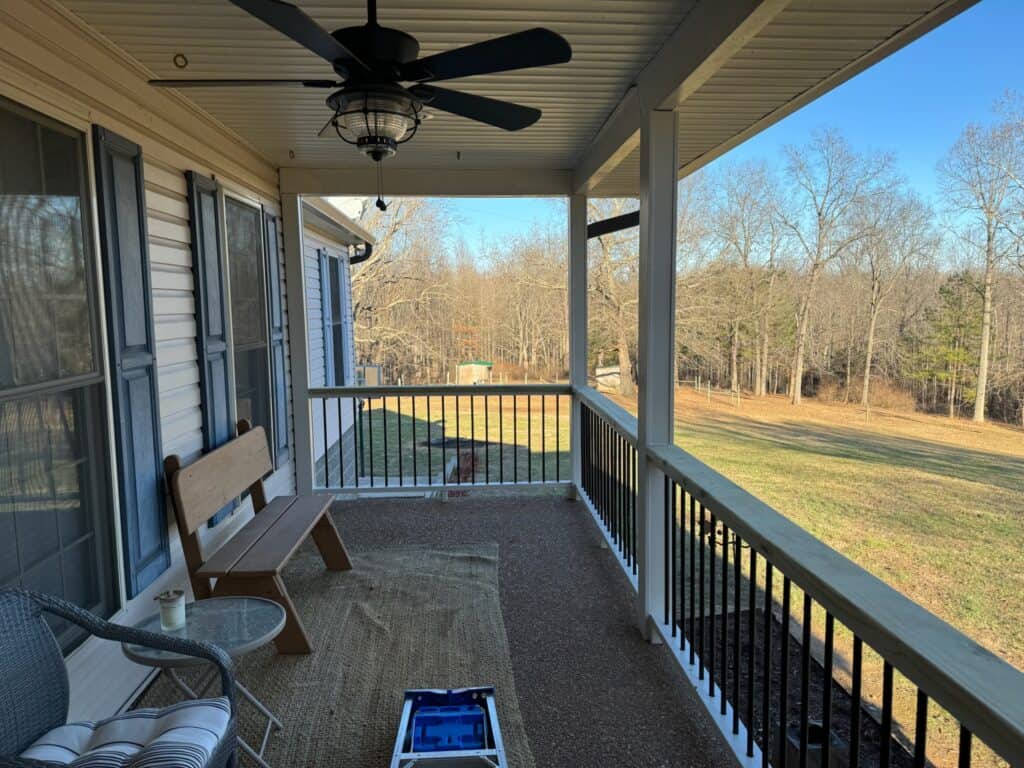 Porch with a ceiling fan, bench seating, and a view of a grassy yard, showcasing outdoor living space design by DW Construction in Nashville, TN.