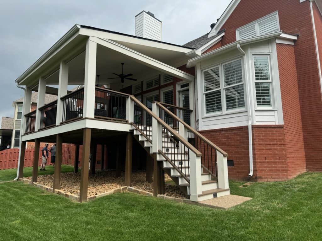 Custom outdoor living space featuring a raised deck with railing, stairs, and a brick home backdrop, showcasing quality craftsmanship by DW Construction in Nashville, TN.